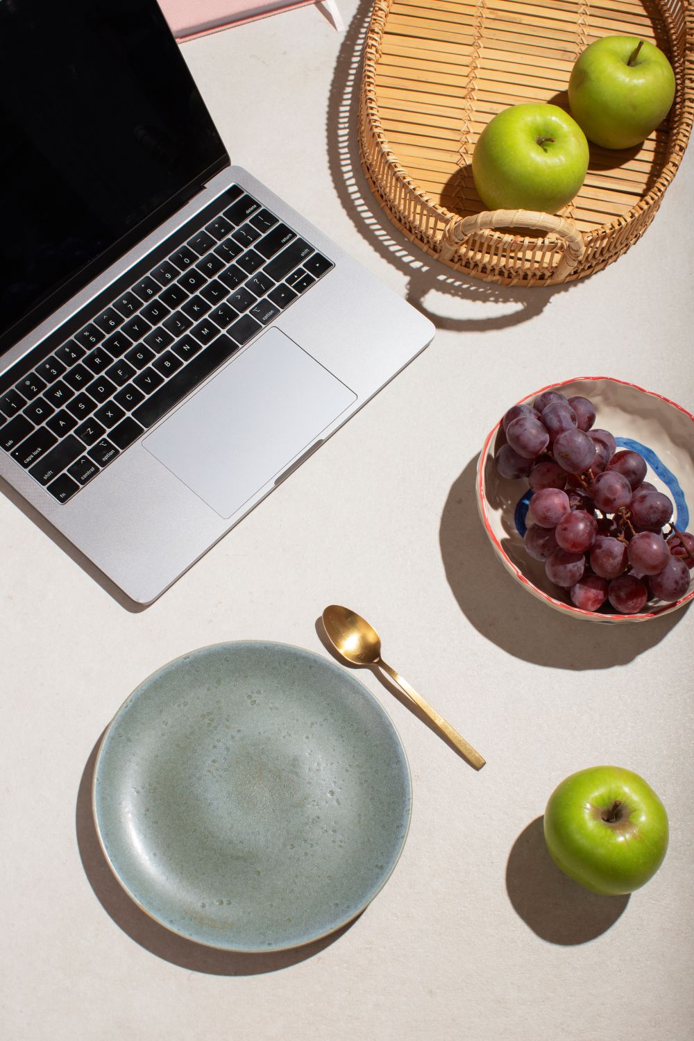 laptop with fruit laying around it